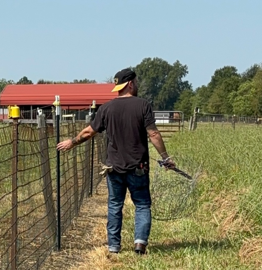 Tyler Ervin walking a fence line on Valley Furnace Farms